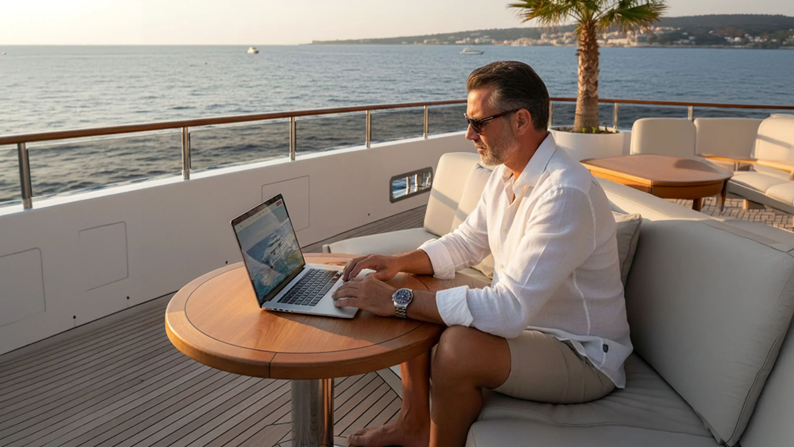 yacht owner researching yacht insurance from the deck while at sea